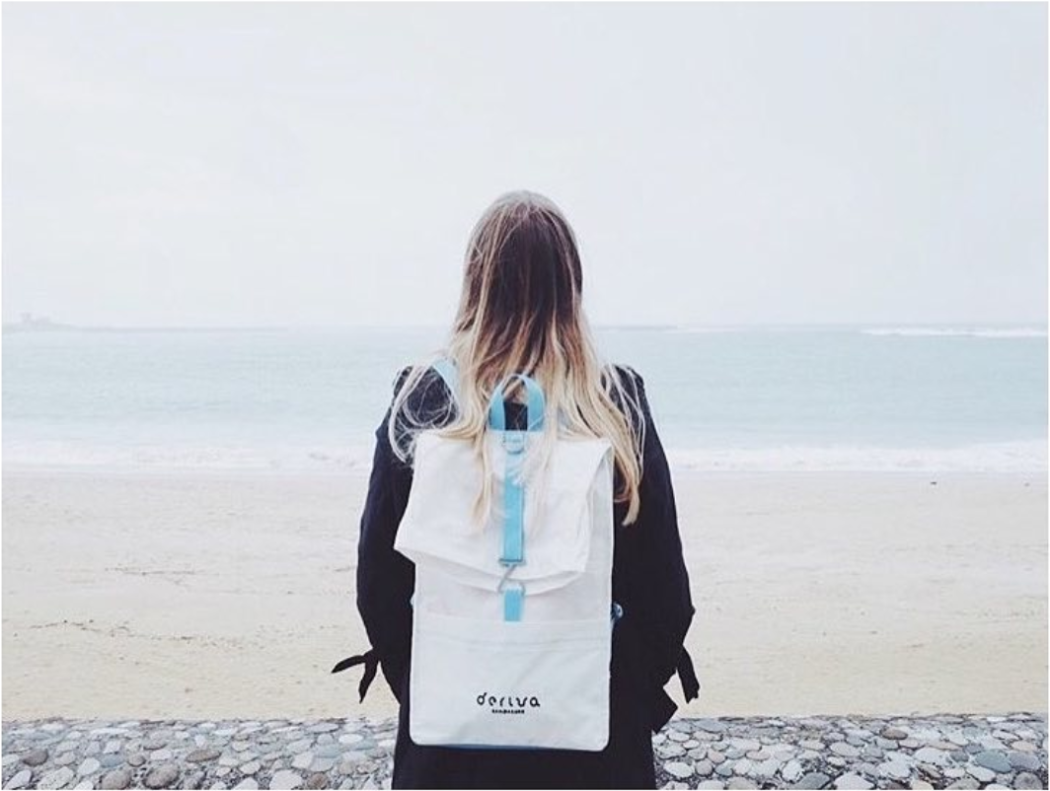 A girl stands with a backpack on her back in front