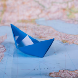 Paper boat on the world map