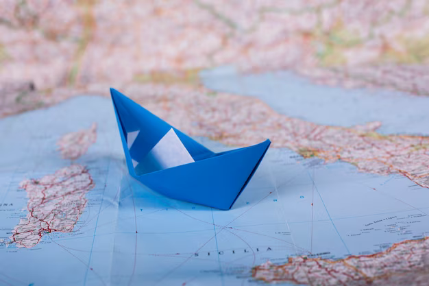 Paper boat on the world map